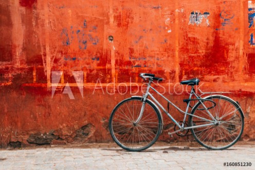 Picture of Old bike standing at colorful red wall